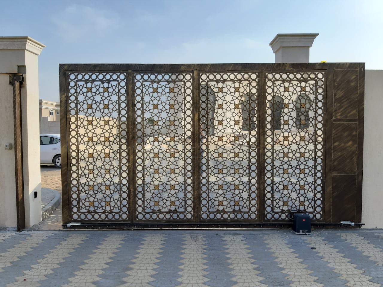 A beautiful patterned gate contrasts the Dubai landscape, capturing modern elegance.